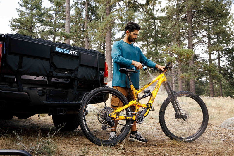 RinseKit's 10-Gallon Tailgate Shower uniquely combines a large water bladder, electric pressurization, and a tailgate pad, creating the first tailgate mounted portable shower designed specifically for mountain bikers. - Courtesy of RinseKit
